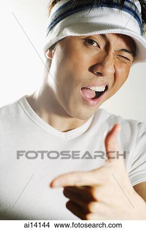 Young man looking at camera, winking and making hand sign View Large Photo Image Picture - Young man looking at camera, winking and making hand sign. Fotosearch