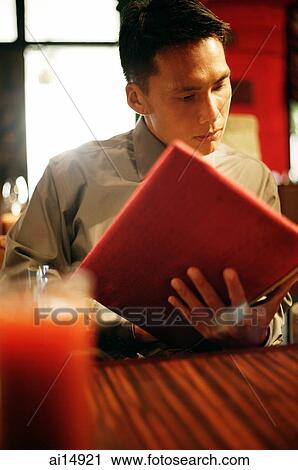Young man looking at menu View Large Photo Image Stock Image - Young man looking at menu. Fotosearch