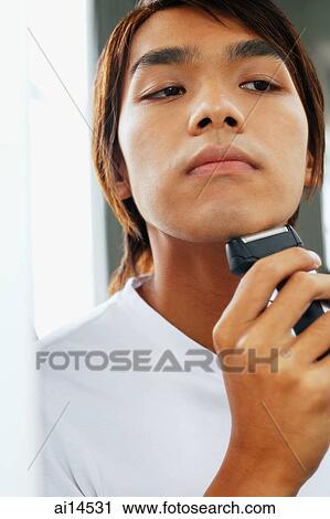 Young man shaving with electric shaver View Large Photo Image Stock Image - Young man shaving with electric shaver. Fotosearch
