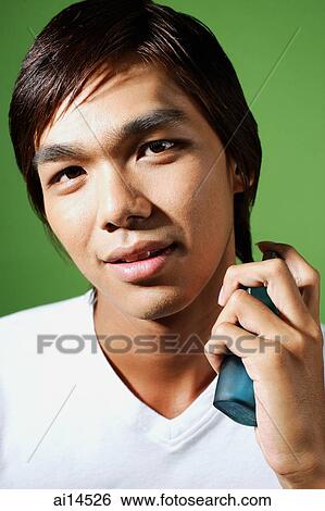 Young man spraying himself with perfume View Large Photo Image Stock Photograph - Young man spraying himself with perfume. Fotosearch