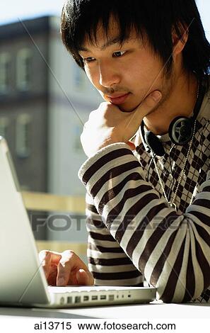 Stock Photography - Young man using laptop. Fotosearch