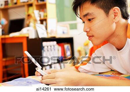 Young man using mobile phone, text messaging View Large Photo Image Stock Image - Young man using mobile phone, text messaging. Fotosearch