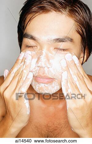 Stock Image - Young man washing face, eyes closed. Fotosearch