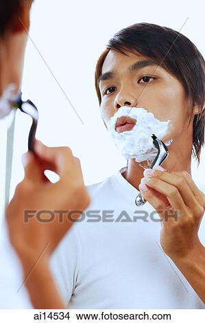 Young man with shaving foam on face, shaving View Large Photo Image Picture - Young man with shaving foam on face, shaving. Fotosearch