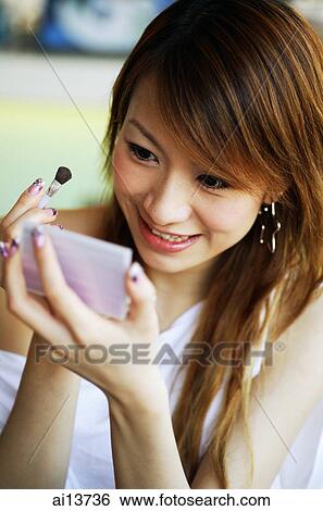 Young woman applying blusher View Large Photo Image Stock Photograph - Young woman applying blusher. Fotosearch