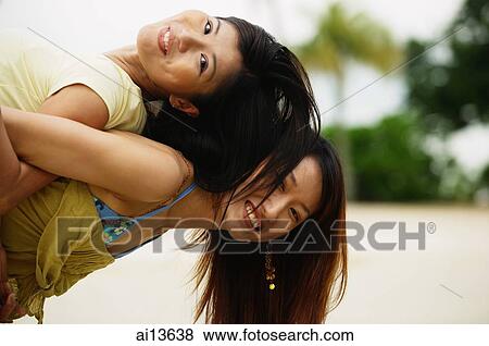 Young woman carrying friend on back, looking at camera View Large Photo Image Stock Photo - Young woman carrying friend on back, looking at camera. Fotosearch