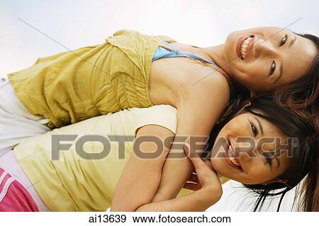 Young woman carrying friend on back, smiling at camera View Large Photo Image Stock Photo - Young woman carrying friend on back, smiling at camera. Fotosearch