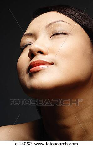 Stock Image - Young woman, eyes closed, smiling. Fotosearch