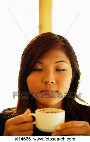 Young woman holding cup of coffee, eyes closed View Large Photo Image Stock Photograph - Young woman holding cup of coffee, eyes closed. Fotosearch