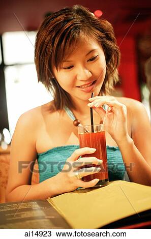 Young woman holding drink with straw View Large Photo Image Stock Image - Young woman holding drink with straw. Fotosearch