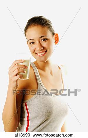 Young woman holding glass of milk, looking at camera View Large Photo Image Stock Image - Young woman holding glass of milk, looking at camera. Fotosearch