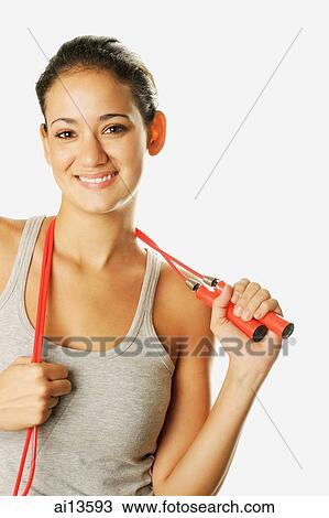 Young woman holding skipping rope over her shoulder, looking at camera View Large Photo Image Stock Image - Young woman holding skipping rope over her shoulder, looking at camera. Fotosearch