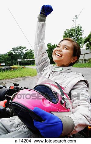 Young woman in go-cart, hands outstretched, smiling, looking away View Large Photo Image Picture - Young woman in go-cart, hands outstretched, smiling, looking away. Fotosearch