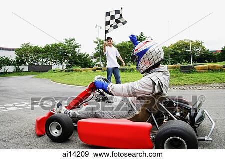 Young woman in go-cart, young man waving flag View Large Photo Image Stock Photo - Young woman in go-cart, young man waving flag. Fotosearch