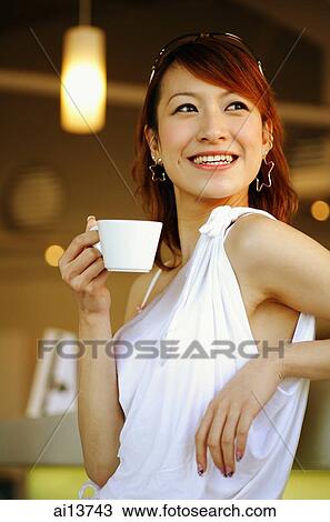 Young woman leaning on bar counter, holding cup View Large Photo Image Stock Image - Young woman leaning on bar counter, holding cup. Fotosearch