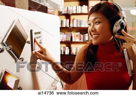 Young woman listening to music, smiling, pressing button View Large Photo Image Stock Photograph - Young woman listening to music, smiling, pressing button. Fotosearch