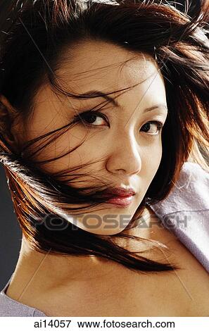 Young woman looking at camera, hair around her face View Large Photo Image Stock Photo - Young woman looking at camera, hair around her face. Fotosearch