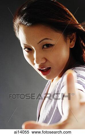 Young woman looking at camera, making a hand sign View Large Photo Image Stock Photography - Young woman looking at camera, making a hand sign. Fotosearch