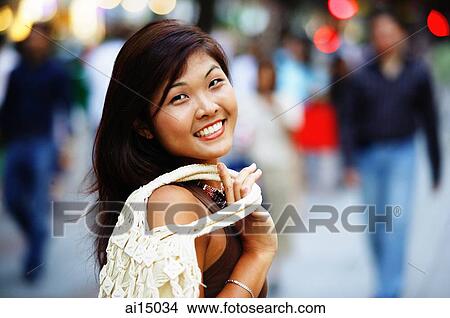 Young woman looking at camera, smiling View Large Photo Image Picture - Young woman looking at camera, smiling. Fotosearch