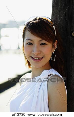 Young woman looking at camera, smiling View Large Photo Image Stock Image - Young woman looking at camera, smiling. Fotosearch