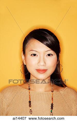 Stock Photo - Young woman looking at camera, smiling, portrait. Fotosearch