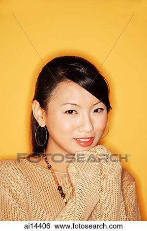 Young woman looking at camera, smiling View Large Photo Image Stock Photograph - Young woman looking at camera, smiling. Fotosearch