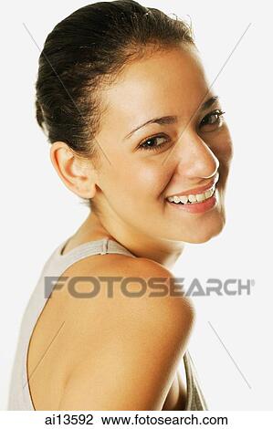 Stock Image - Young woman looking over shoulder at camera. Fotosearch