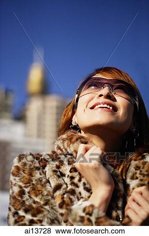 Young woman looking up, wearing sunglasses and fur coat View Large Photo Image Stock Photo - Young woman looking up, wearing sunglasses and fur coat. Fotosearch