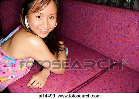 Young woman lying on sofa, looking at camera View Large Photo Image Stock Photo - Young woman lying on sofa, looking at camera. Fotosearch