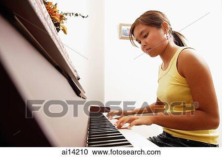 Young woman sitting at piano, looking down View Large Photo Image Stock Image - Young woman sitting at piano, looking down. Fotosearch