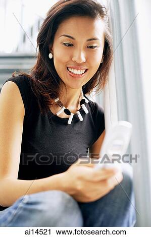 Young woman, sitting on steps, using mobile phone View Large Photo Image Stock Image - Young woman, sitting on steps, using mobile phone. Fotosearch