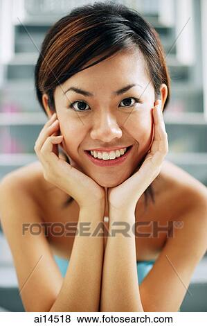 Young woman, smiling at camera, hands on face View Large Photo Image Stock Photo - Young woman, smiling at camera, hands on face. Fotosearch
