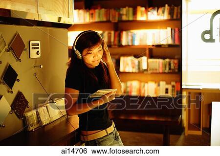 Young woman standing, listening to music, holding CD View Large Photo Image Stock Photograph - Young woman standing, listening to music, holding CD. Fotosearch