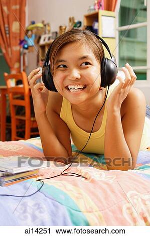 Young woman wearing headphones, looking away View Large Photo Image Stock Image - Young woman wearing headphones, looking away. Fotosearch
