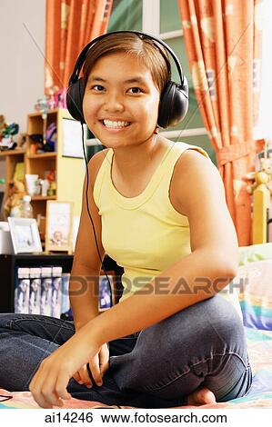 Young woman wearing headphones, looking at camera View Large Photo Image Stock Photograph - Young woman wearing headphones, looking at camera. Fotosearch