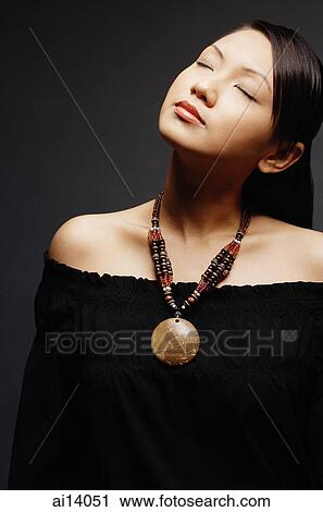 Young woman wearing necklace, eyes closed View Large Photo Image Stock Image - Young woman wearing necklace, eyes closed. Fotosearch