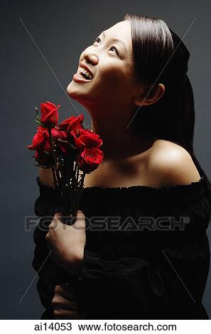 Young woman with bouquet of flowers, looking up View Large Photo Image Stock Image - Young woman with bouquet of flowers, looking up. Fotosearch