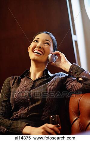 Young woman with champagne glass, using mobile phone View Large Photo Image Stock Photography - Young woman with champagne glass, using mobile phone. Fotosearch