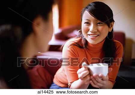 Young woman with cup, facing another woman View Large Photo Image Stock Photography - Young woman with cup, facing another woman. Fotosearch