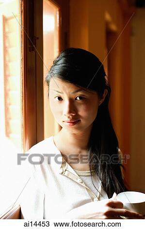 Young woman with cup, looking at camera, portrait View Large Photo Image Stock Image - Young woman with cup, looking at camera, portrait. Fotosearch