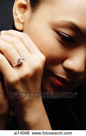 Young woman with ring on finger, head shot View Large Photo Image Stock Photo - Young woman with ring on finger, head shot. Fotosearch
