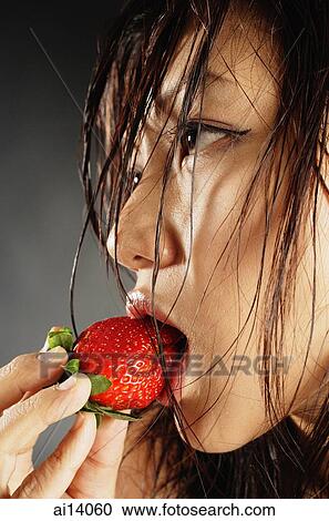 Young woman with wet hair, eating a strawberry View Large Photo Image Stock Image - Young woman with wet hair, eating a strawberry. Fotosearch