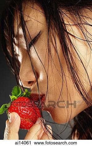 Young woman with wet hair, kissing a strawberry View Large Photo Image Stock Image - Young woman with wet hair, kissing a strawberry. Fotosearch