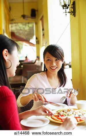 Young women at cafe, eating pizza View Large Photo Image Stock Photo - Young women at cafe, eating pizza. Fotosearch