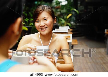 Young women having coffee, over the shoulder view View Large Photo Image Stock Image - Young women having coffee, over the shoulder view. Fotosearch