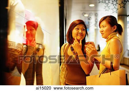 Young women looking at window display, talking View Large Photo Image Stock Image - Young women looking at window display, talking. Fotosearch