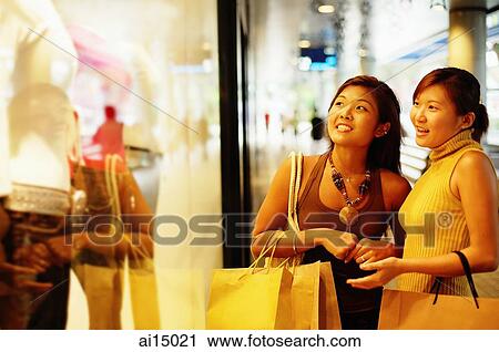 Young women looking at window display, pointing View Large Photo Image Stock Image - Young women looking at window display, pointing. Fotosearch