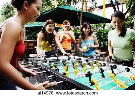Stock Photo - Young women playing foosball. Fotosearch