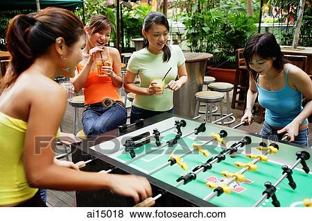 Young women playing foosball View Large Photo Image Stock Photo - Young women playing foosball. Fotosearch