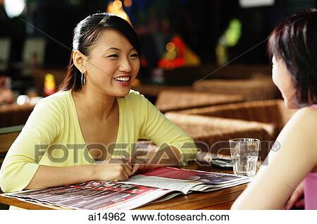 Young women sitting across each other, talking View Large Photo Image Stock Image - Young women sitting across each other, talking. Fotosearch